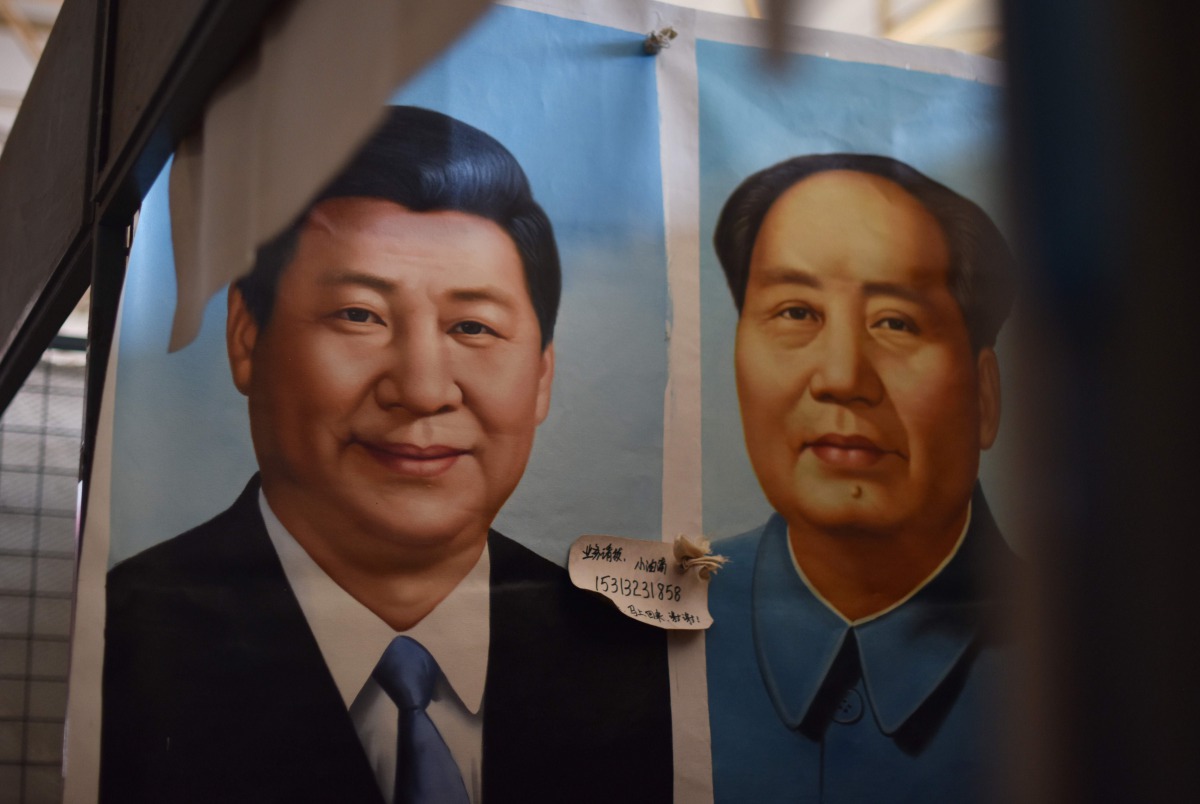 This file picture taken on September 19, 2017 shows painted portraits of Chinese President Xi Jinping (L) and late communist leader Mao Zedong at a market in Beijing. AFP / Greg Baker