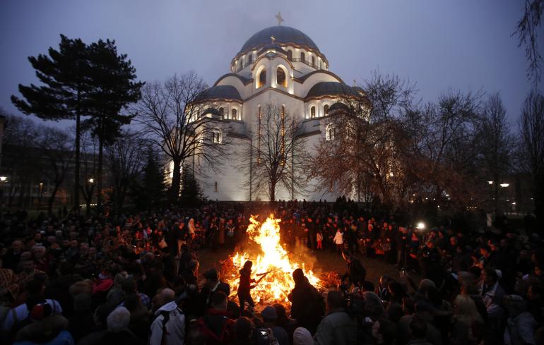 Serbian Orthodox believers burn dried oak branches, which symbolize the Yule log, on Orthodox Christmas Eve in front of the St. Sava Church in Belgrade, January 6, 2014.  (Reuters) 

