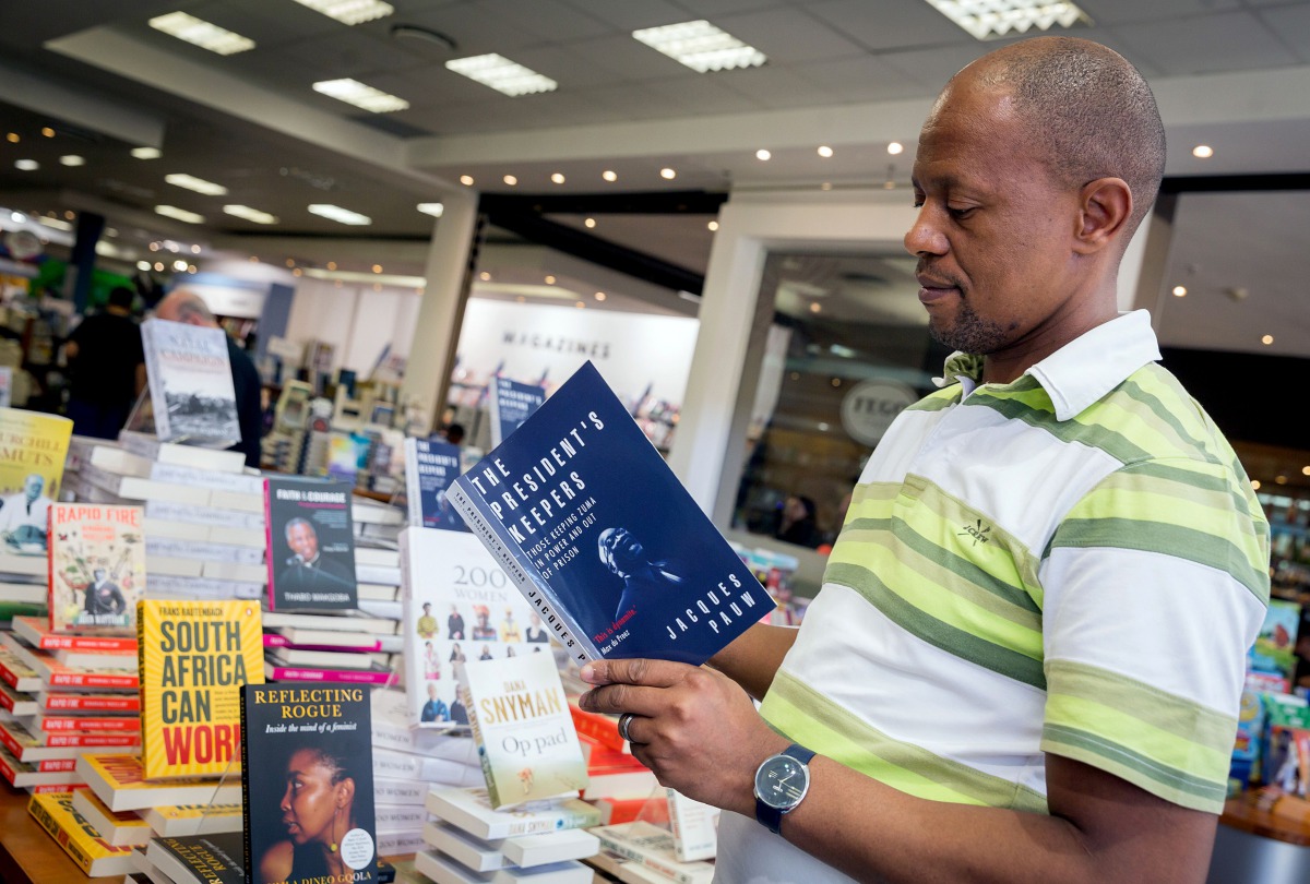 A staff member of the Exclusive Books bookshop at the Gateway Mall in Durban holds the book 