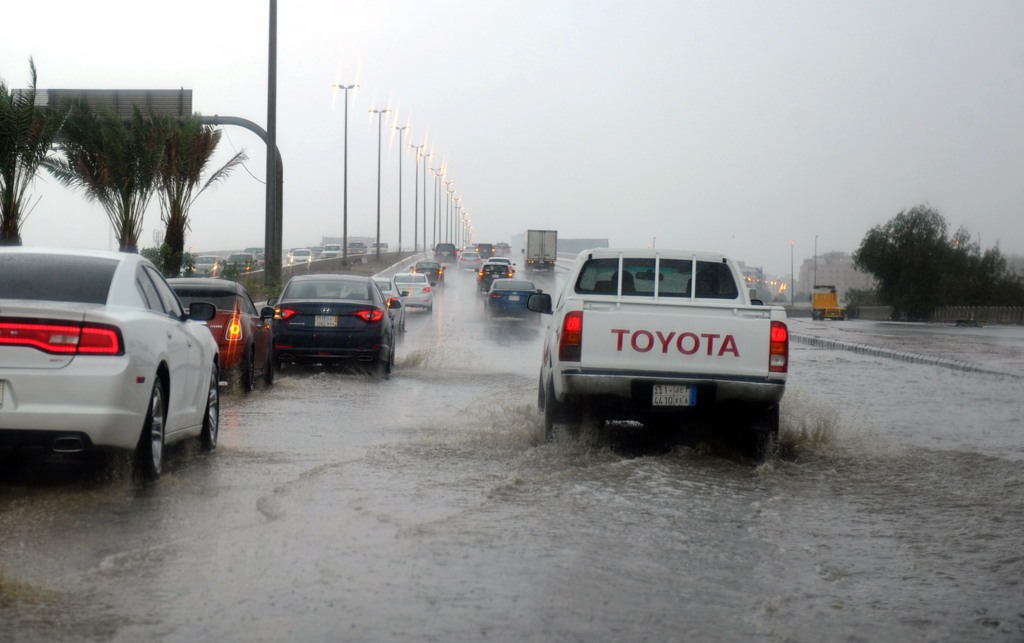 Saudi drivers take a flooded street in Jeddah on November 21, 2017. / AFP / Amer HILABI