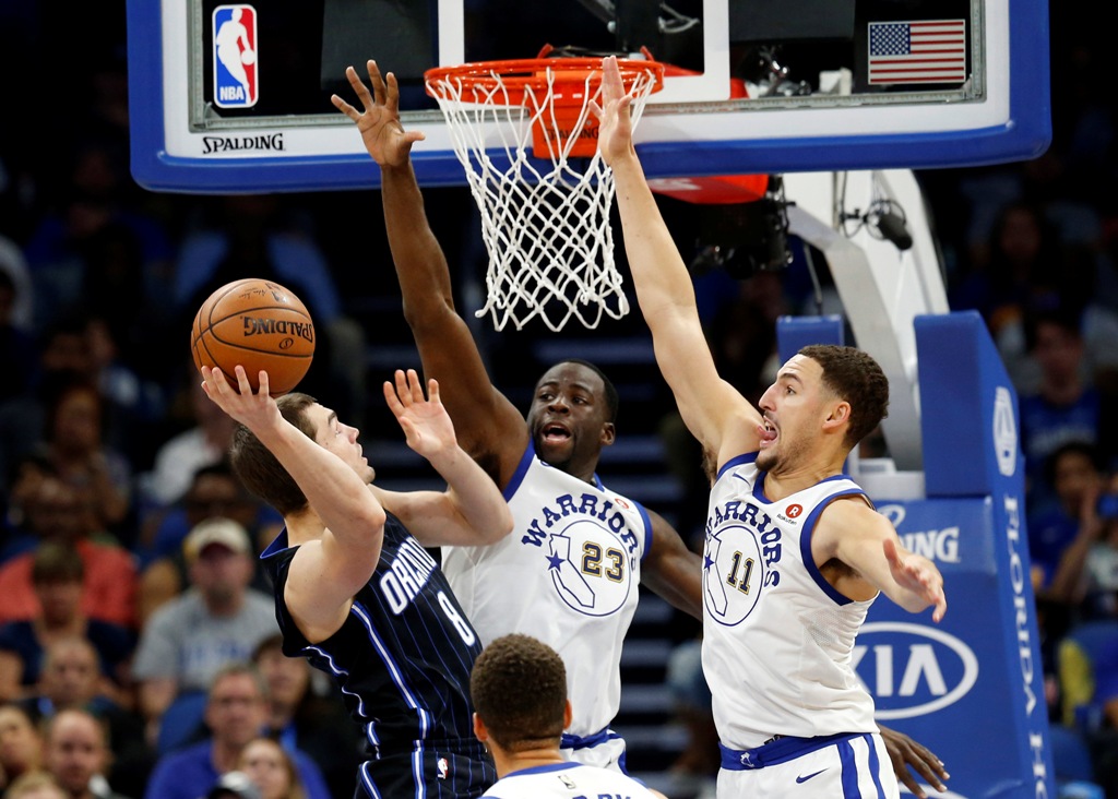 Orlando Magic guard Mario Hezonja (8) shoots over Golden State Warriors forward Draymond Green (23) and guard Klay Thompson (11) during the second quarter at Amway Center. Kim Klement
