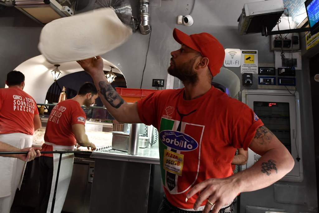 Neapolitan pizza makers prepare pizzas in a bottega on December 6, 2017 in Naples. AFP / Tiziana FABI