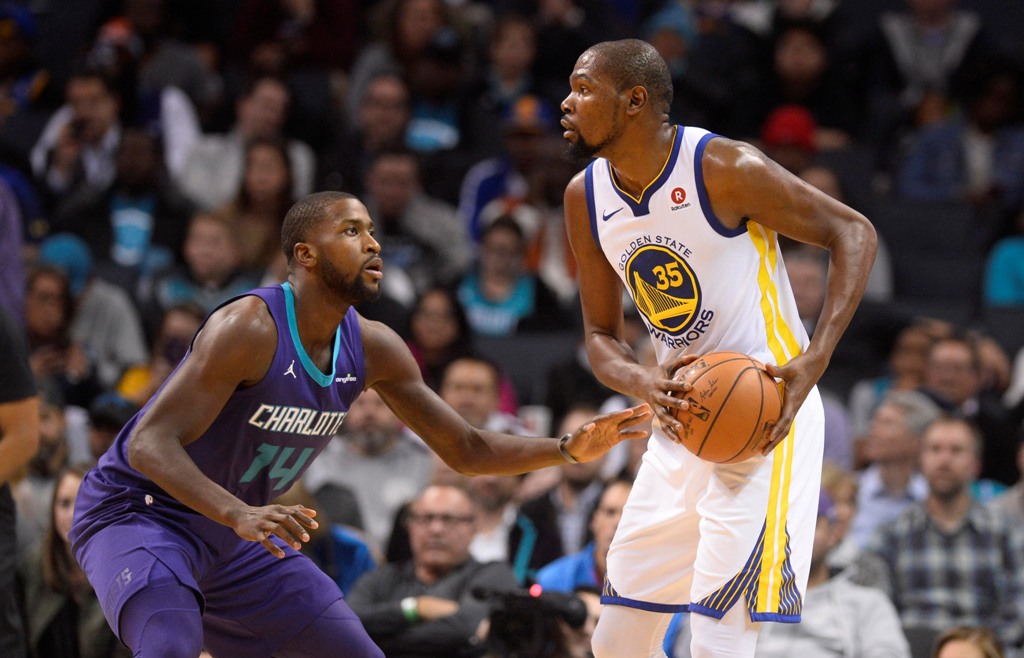 Golden State Warriors forward Kevin Durant (35) tries to pass against Charlotte Hornets forward Michael Kidd-Gilchrist (14) during the second half at the Spectrum Center. Sam Sharpe
