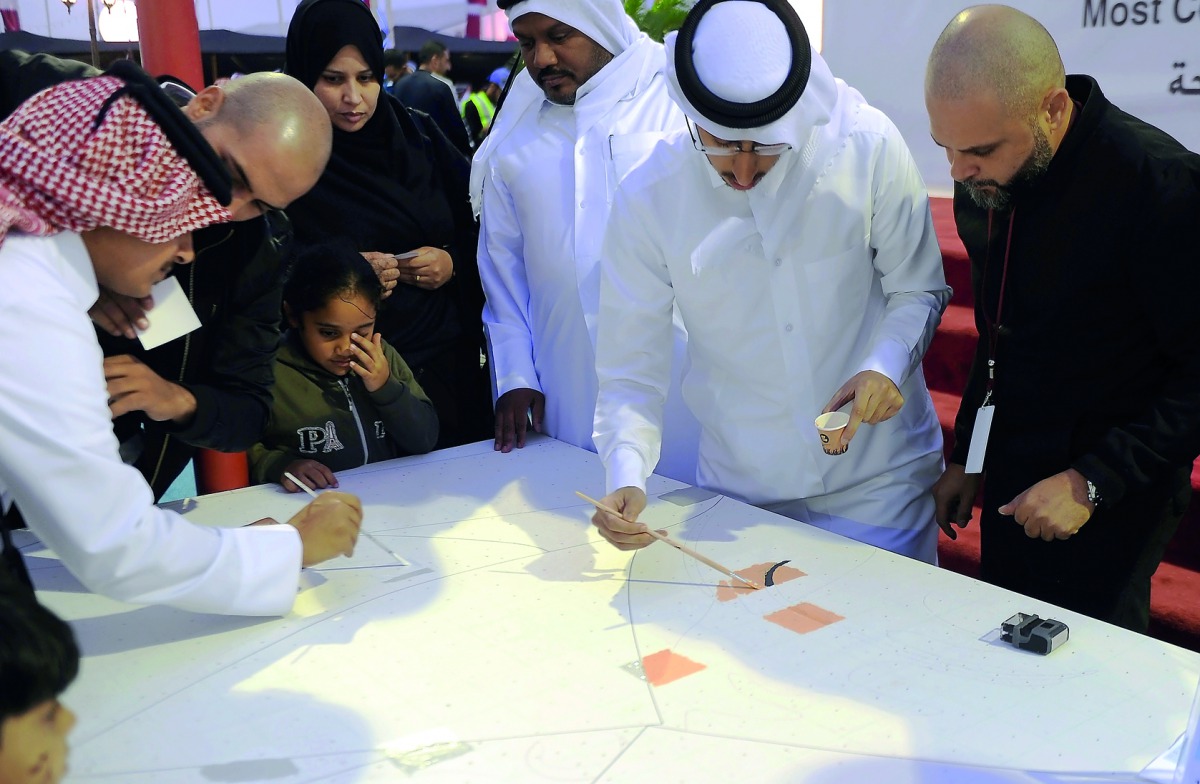 People participating in ‘The Dignity’ Image painting at Darb Al Saai yesterday.