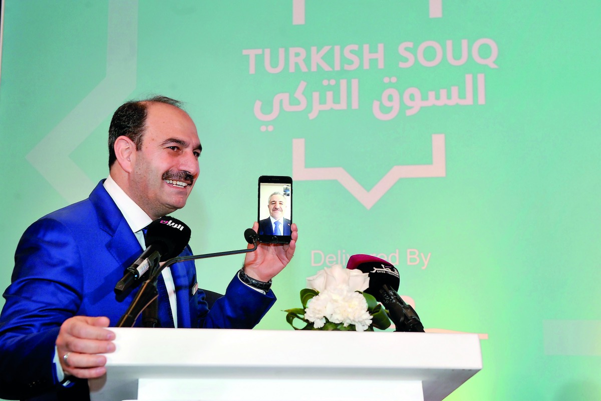 Ahmet Arslan  addressing the launching ceremony of Turkish Souq via FaceTime from Turkey. Kenan Bozgeyik, CEO of Turkish Post (PTT) is holding the phone.  Pic: Kammutty VP/The Peninsula