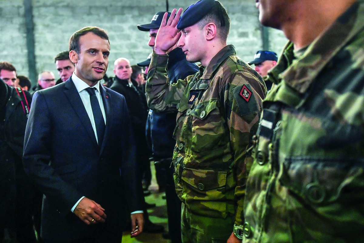 French President Emmanuel Macron (L) speaks to soldiers as he meets security forces during his visit in the French northern city of Calais on January 16, 2018. French President Emmanuel Macron travelled to the northern French port of Calais ahead of a sum