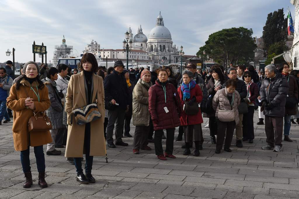 Tourists stroll near Piazza San Marco in Venice, on January 19, 2018. / AFP / Andrea Pattaro 