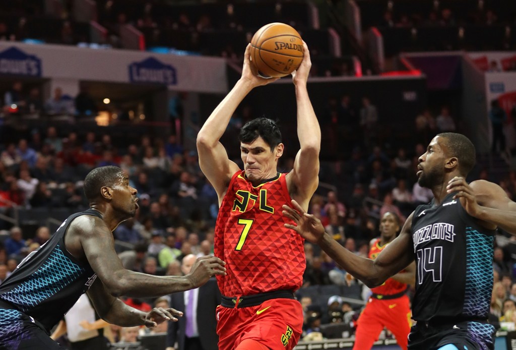 Ersan Ilyasova #7 of the Atlanta Hawks drives to the basket against teammates Marvin Williams #2 and Michael Kidd-Gilchrist #14 of the Charlotte Hornets during their game at Spectrum Center on January 26, 2018 in Charlotte, North Carolina. Streeter Lecka/