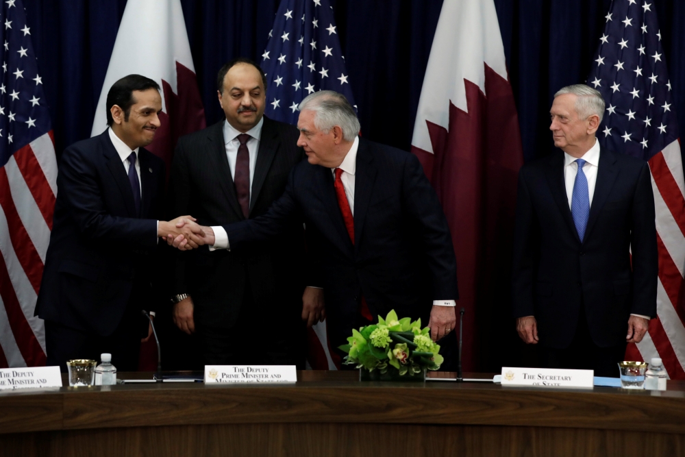 U.S. Defense Secretary Jim Mattis (R) looks on as Secretary of State Rex Tillerson shakes hands with Qatari Foreign Minister Sheikh Mohammed bin Abdulrahman Al Thani (L) and Defense Minister Khalid bin Muhammad al-Attiyah at the opening session of the ina