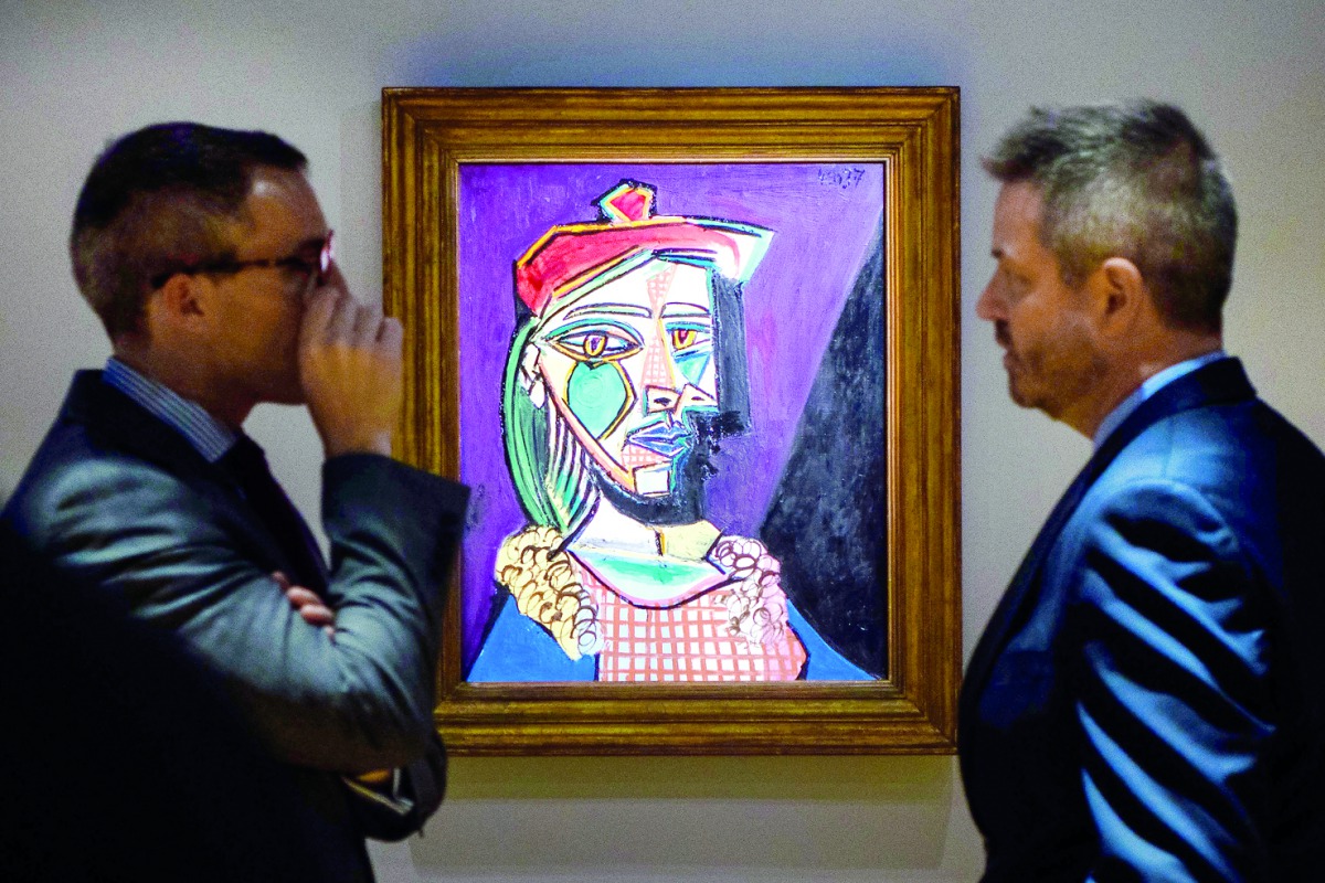 James Mackie (left), Sotheby’s Senior Director and Head of the Department Impressionist and Modern Art, speaks with a colleague in front of Pablo Picasso’s 1937 oil painting during a media preview at the Sotheby’s showroom in Hong Kong, yesterday. 