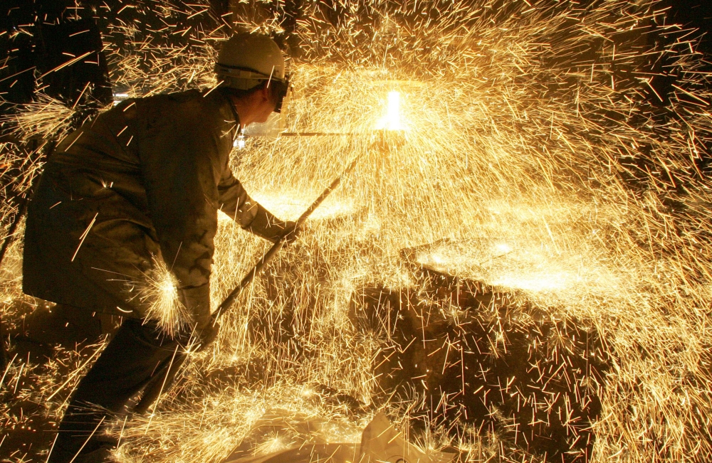 In this file photo taken on April 12, 2006 an iron and steel worker makes a test on a casting at Ascometal factory in Fos-sur-Mer, south-eastern France. AFP / Boris Horvat