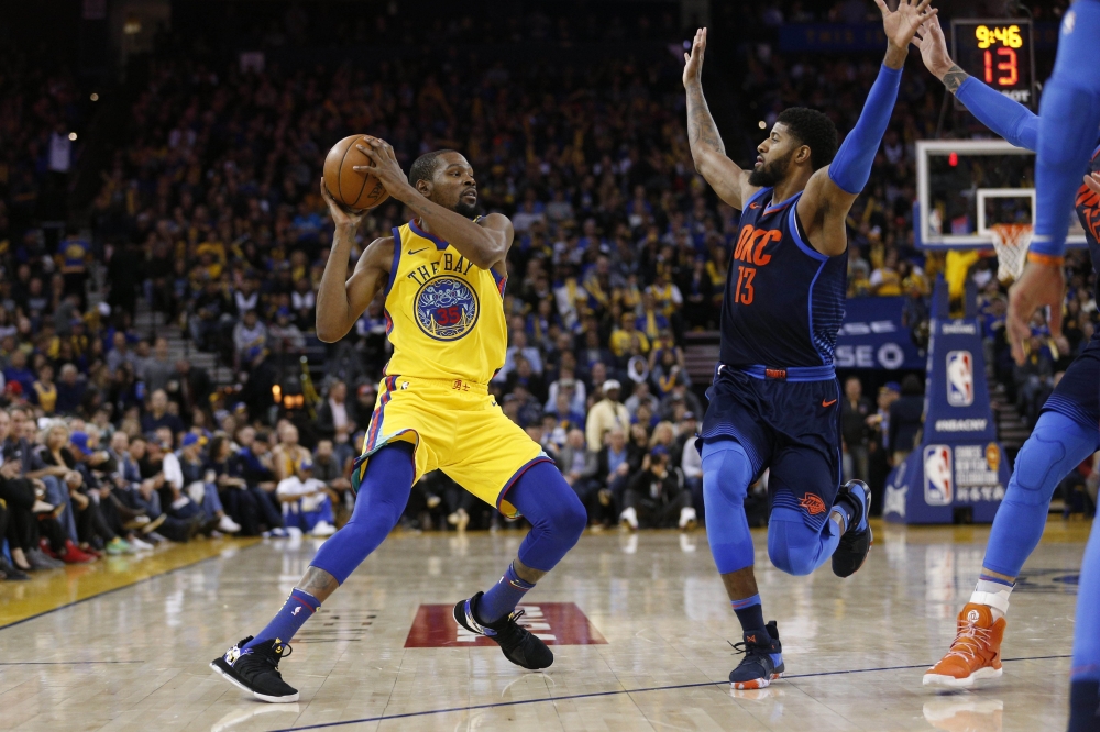 Oakland, CA, USA; Golden State Warriors forward Kevin Durant (35) picks up his dribble against Oklahoma City Thunder forward Paul George (13) in the third quarter at Oracle Arena. Cary Edmondson