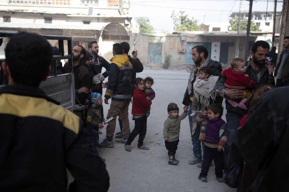 Syrian's flee their homes in the town of Beit Sawa in Syria's besieged eastern Ghouta region on March 4, 2018, following reported air strikes.  AFP / Abdulmonam Eassa