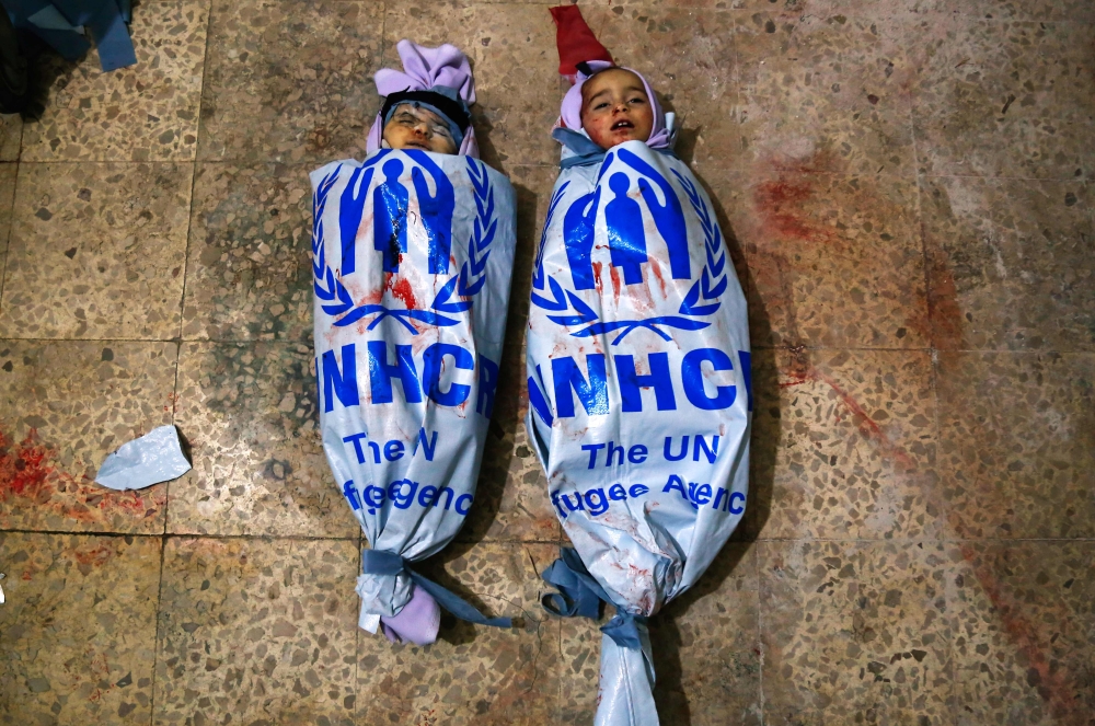 The bodies of children who were killed in shelling on the city of Douma are seen at a make-shift morgue in the rebel-held enclave of Eastern Ghouta on March 4, 2018. AFP / Hasan Mohamed

