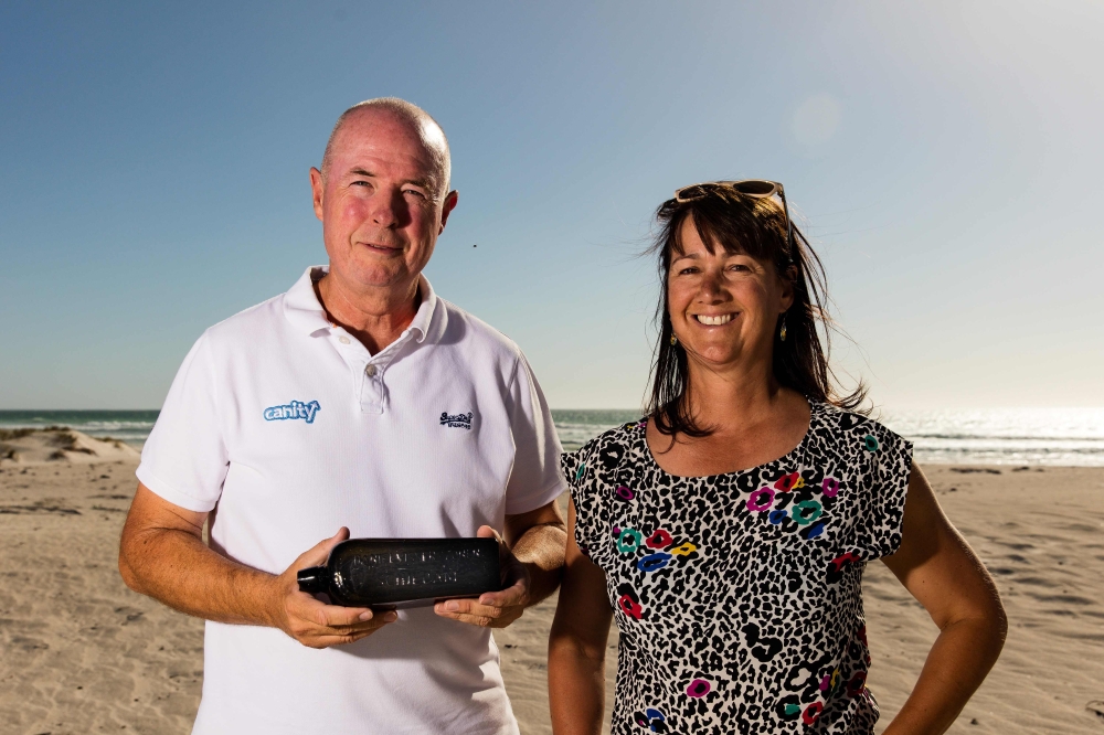 This undated photo received courtesy from Kym Illman on March 7, 2018 shows Kym Illman (L) and his wife Tonya posing with a bottle which contained an almost 132-year-old message that was found near Wedge Island, some 160 kilometres (99 miles) north of Per