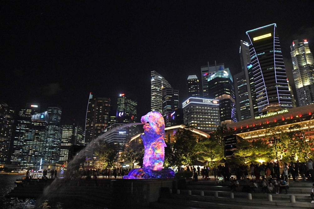 Merlion statue lit up in front of the city skyline in Singapore. The eye-watering cost of owning a car in space-starved Singapore means the city state is the world's most expensive place to live for the fifth year in a row, a survey said on March 15. (AFP