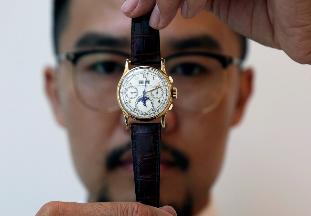 An exhibitor displays the Patek Philippe 18k gold perpetual chronograph wrist watch with moon phases belonging to the King Farouk, at the Christie's auction in Dubai, United Arab Emirates, March 19, 2018. Reuters/Satish Kumar