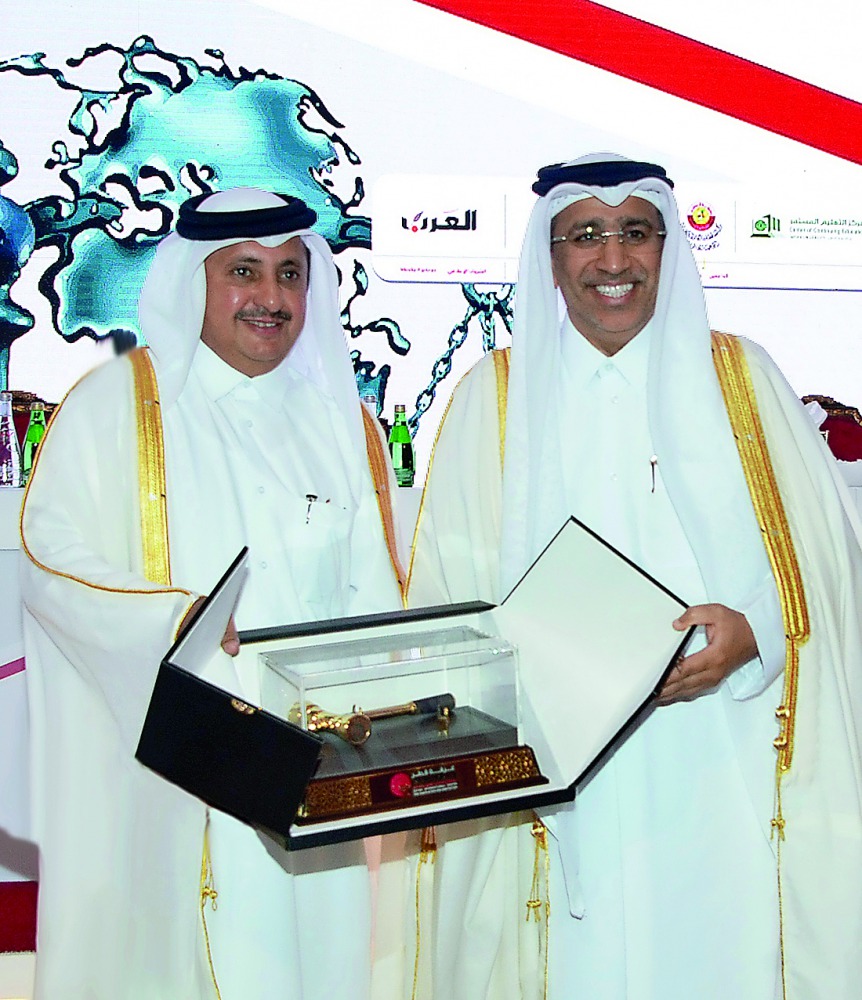 Minister of Justice H E Dr Hassan Lahdan Saqr Al Mohannadi (right), being honoured by Chairman of Qatar Chamber,  Sheikh Khalifa bin Jassim Al Thani, during the 3rd International Arbitration Conference at Ritz-Carlton Doha, yesterday.