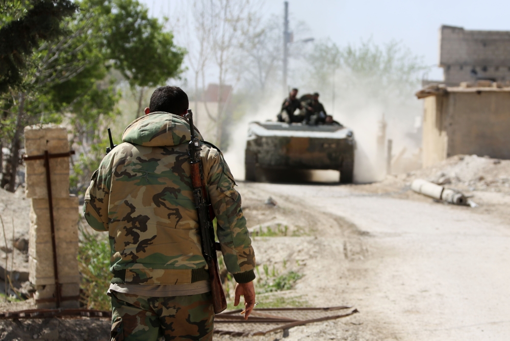 Syrian pro-regime forces advance on the outskirts of Ain Tarma in Eastern Ghouta as they continue to press their offensive to capture the rebel-held enclave on the doorstep of Damascus on March 21, 2018. / AFP / STRINGER