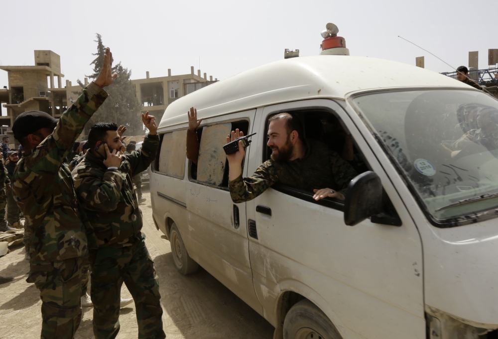 A vehicle transporting civilians and soldiers who the regime says were kidnapped by rebels and liberated in a prisoner swap arrive in a government-held area at the entrance of Harasta in Eastern Ghouta, on the outskirts of Damascus, on March 22, 2018, aft