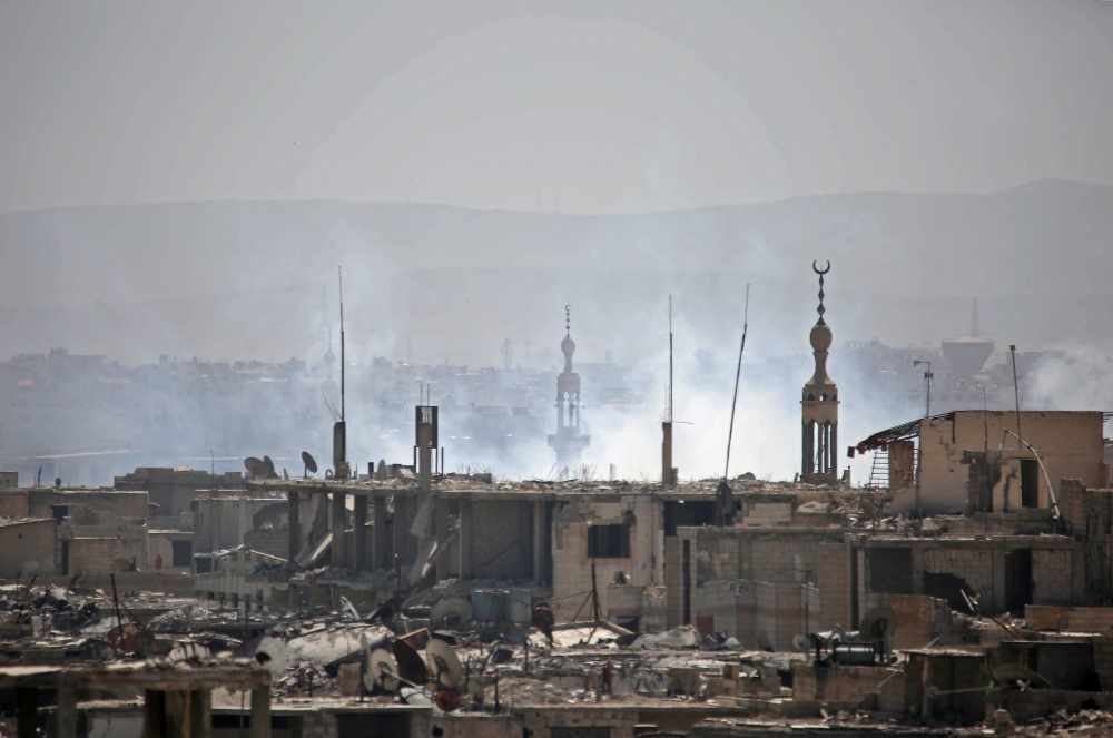 (FILE PHOTO) A picture taken on March 20, 2018 shows smoke plumes rising during regime bombardment in the rebel-held town of Arbin in the Eastern Ghouta enclave outside the capital Damascus. AFP / Amer ALMOHIBANY
