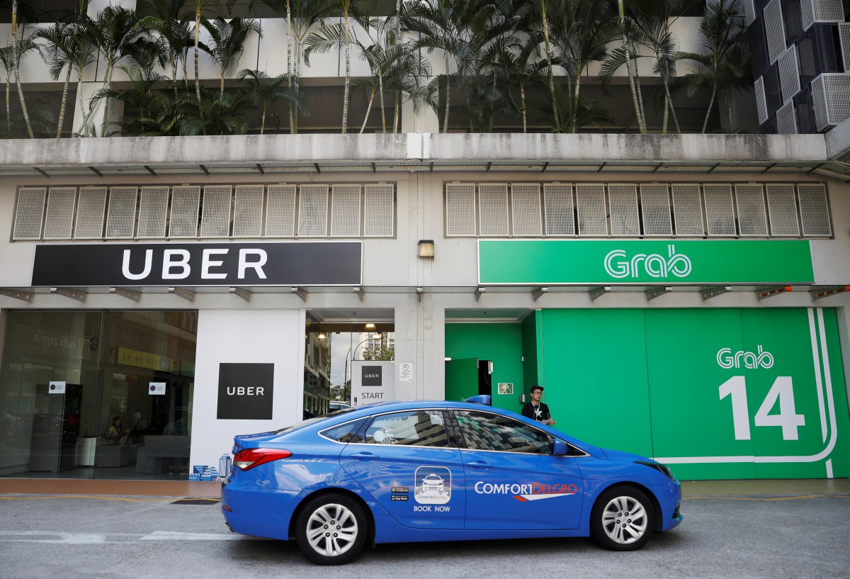 A ComfortDelgro taxi passes Uber and Grab offices in Singapore March 26, 2018. Reuters/Edgar Su