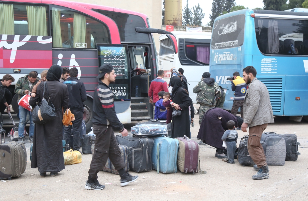 Syrian civilians are seen as the sixth convoy of vehicles carrying civilians and opposition fighters from the Damascus suburb of Eastern Ghouta arrived in the Hama province in west-central Syria on March 28, 2018.  Enes Diyab - Anadolu
