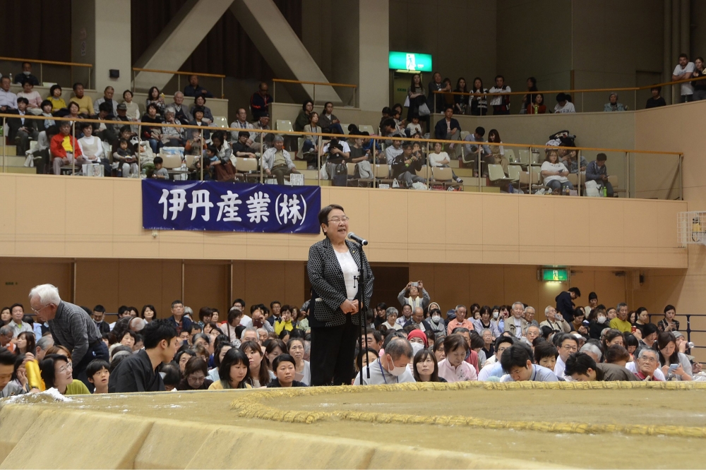 Tomoko Nakagawa (C), the mayor of the western Japanese city of Takarazuka, delivering a speech outside the sumo ring (R) during a local exhibition in Takarazuka, Hyogo prefecture on April 6, 2018. AFP Photo / Takarazuka City