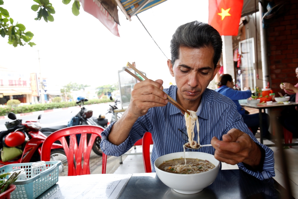 Vietnamese deportee and Amerasian Pham Chi Cuong, 47, who was deported from U.S., eats along a street in central Ho Chi Minh City, Vietnam April 20, 2018, Reuters/Kham