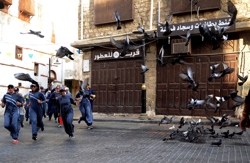 Saudi women jog in the streets of Jeddah's historic al-Balad district on March 8, 2018.  Amer Hilabi