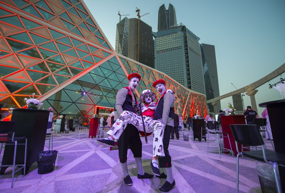 Mime actors holding another outside the AMC cinema in the capital Riyadh ahead of the first test film screening in over three decades.  AFP photo / Saudi Royal Palace / Bandar Al-Jaloud
