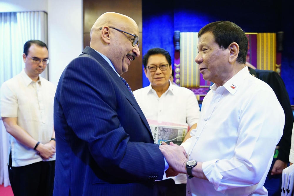 Philippine President Rodrigo Duterte (R) meeting Kuwaiti Ambassador to the Philippines Musaed Saleh Ahmad Althwaikh (L) at the presidential guest house in Davao City, in southern island of Mindanao, as Philippines' Foreign Secretary Alan Cayetano (back, L