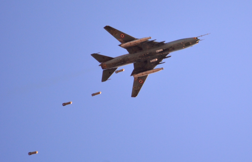 A Sukhoi Su-22 Syrian army plane releases bombs over southern Damascus in the area of Yarmuk Palestinian refugee camp on April 24, 2018.  AFP / Rami al SAYED
