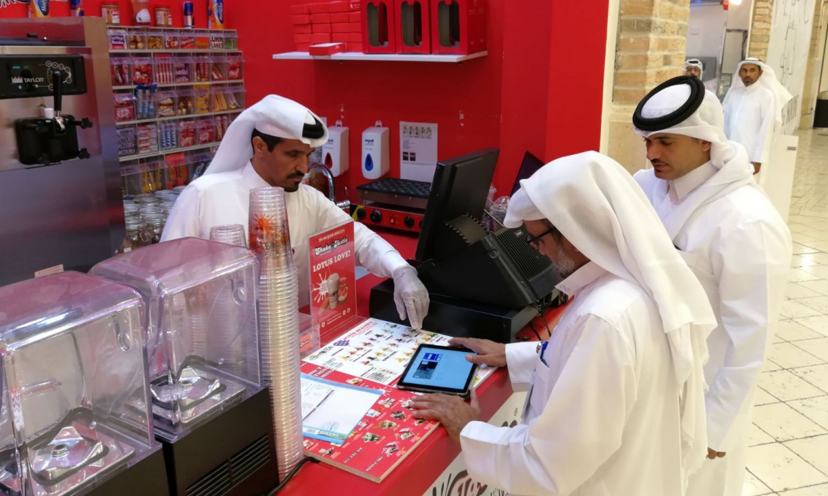 A municipal inspector is booking a violation using the new device at a food outlet in Al Rayyan Municipality during the pre-Ramadan inspection drive.