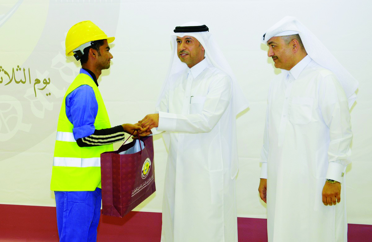 Minister of Administrative Development, Labour and Social Affairs, H E Dr Issa bin Saad Al Jafali Al Nuaimi (centre), honouring one of the workers. 