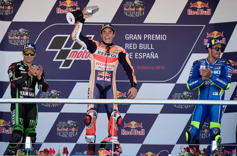 First placed Repsol Honda Team's Spanish rider Marc Marquez (C), second placed Monster Yamaha Tech 3's French rider Johann Zarco (L) and third placed Team SUZUKI ECSTAR's Italian rider Andrea Iannone celebrate on the podium after the MotoGP race of the Sp