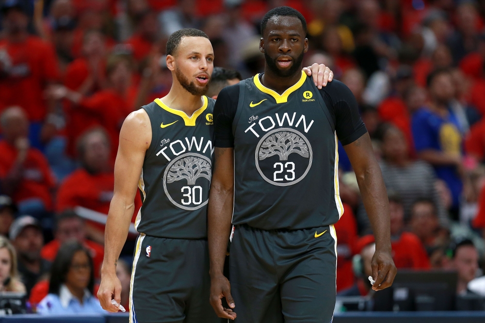 Stephen Curry #30 of the Golden State Warriors stands on the court with Draymond Green #23 of the Golden State Warriors during the first half of Game Four of the Western Conference Semifinals of the 2018 NBA Playoffs at the Smoothie King Center on May 6, 