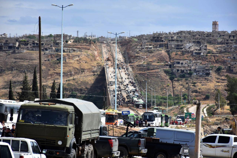 People on the outskirts of the Syrian rebel town of Rastan in the Homs province, heading toward busses to be evacuated.  May 7, 2018. AFP / SANA