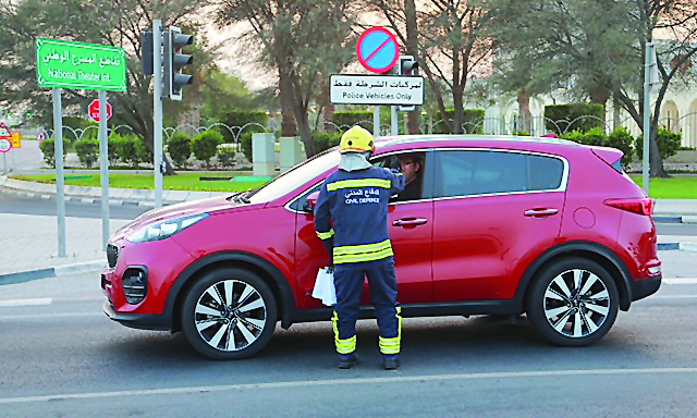 The General Directorate of Civil Defence personnel wearing fire fighting suits distributing Iftar meals.