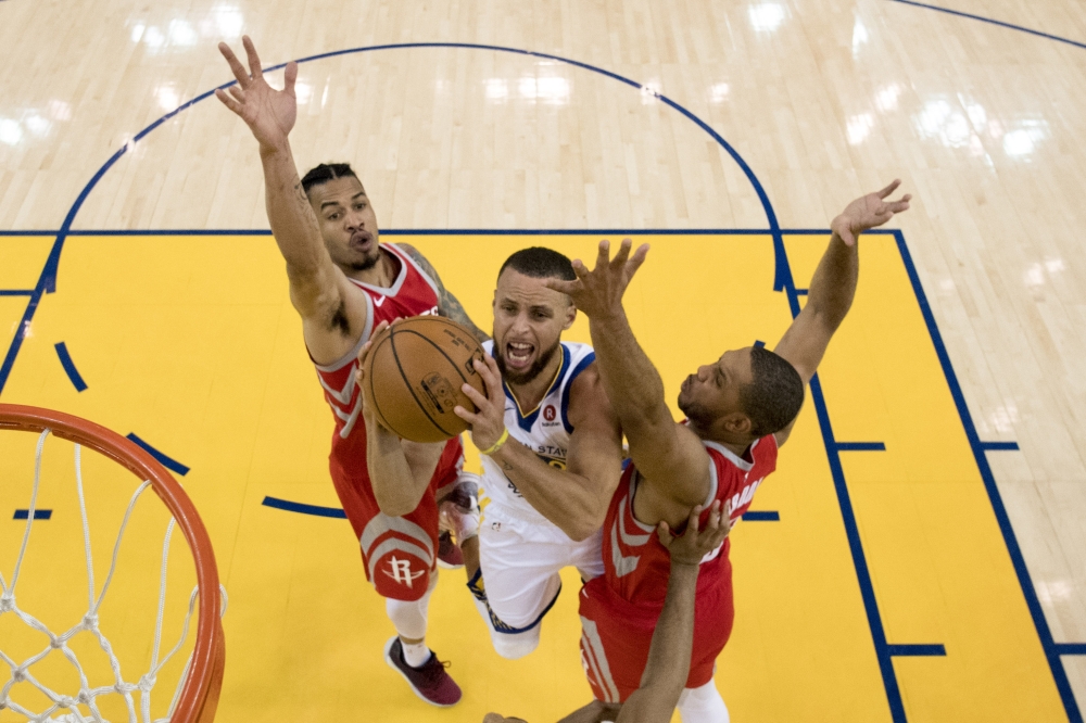 Golden State Warriors guard Stephen Curry (30) shoots the basketball against Houston Rockets guard Gerald Green (14) and guard Eric Gordon (10) during the first half in game three of the Western conference finals of the 2018 NBA Playoffs at Oracle Arena. 