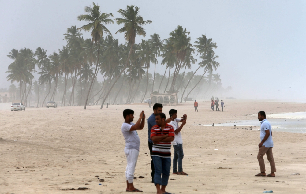 Omanis take pictures on the beach as high waves break along the shore in the southern city of Salalah on May 24, 2018 as the country prepares for landfall of Cyclone Mekunu.  AFP / Mohammed Mahjoub