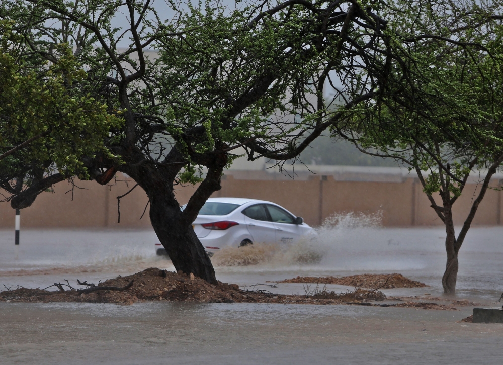 A picture taken on May 25, 2018, shows cars driving through a flooded street in the southern city of Salalah as the country prepares for landfall of Cyclone Mekunu. Heavy rains and strong winds pummelled Dhofar province, with an AFP photographer in Salala