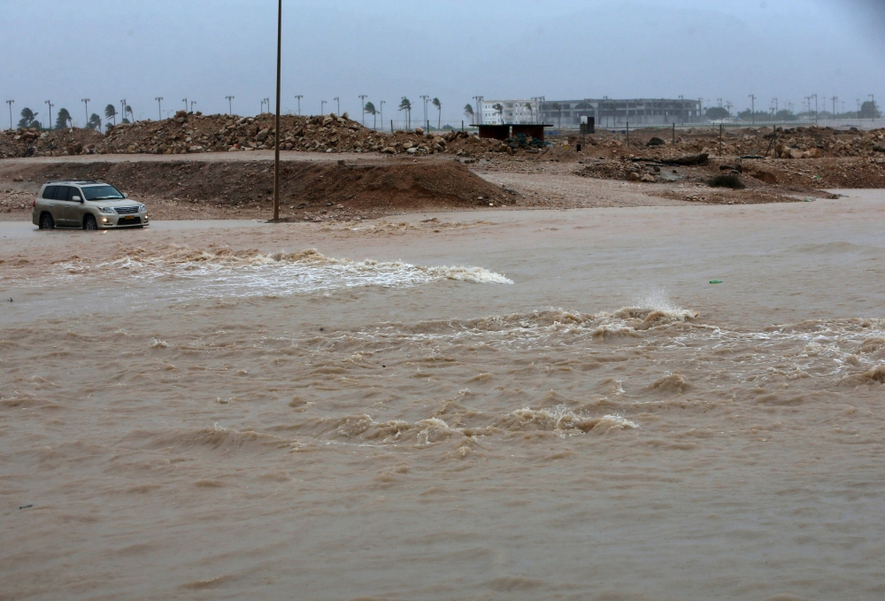 A picture taken on May 25, 2018, shows a car driving through a flooded street in the southern city of Salalah as the country prepares for landfall of Cyclone Mekunu. AFP / Mohammed Mahjoub