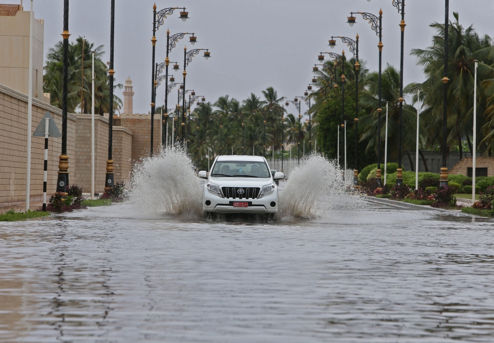 A picture taken on May 25, 2018, shows cars driving through a flooded street in the southern city of Salalah as the country prepares for landfall of Cyclone Mekunu. AFP / MOHAMMED MAHJOUB