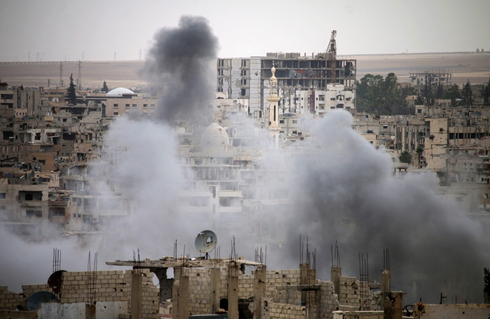 Smoke rises from buildings in a rebel-held neighbourhood of Daraa in southern Syria following reported shelling by the regime on May 22, 2018. / AFP / Mohamad ABAZEED