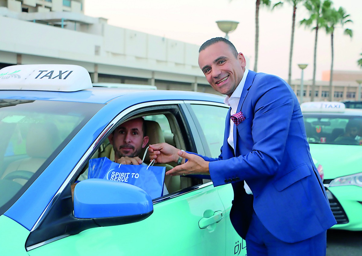 A staff of a Marriott Hotel in Qatar hands over Iftar kit to a cab driver. 