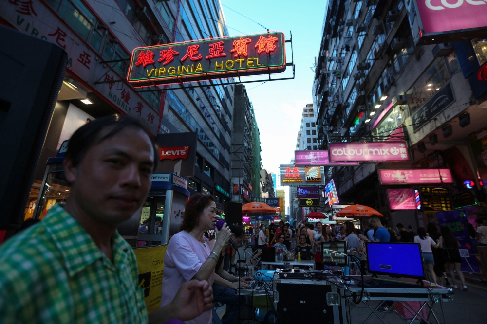 Buskers perform along Sai Yeung Choi street in the Mong Kok area of Hong Kong on May 26, 2018. The road, which has been a pedestrian zone on the weekends for 18 years, will be cleared in the coming weeks of all street performers and shoppers and opened up