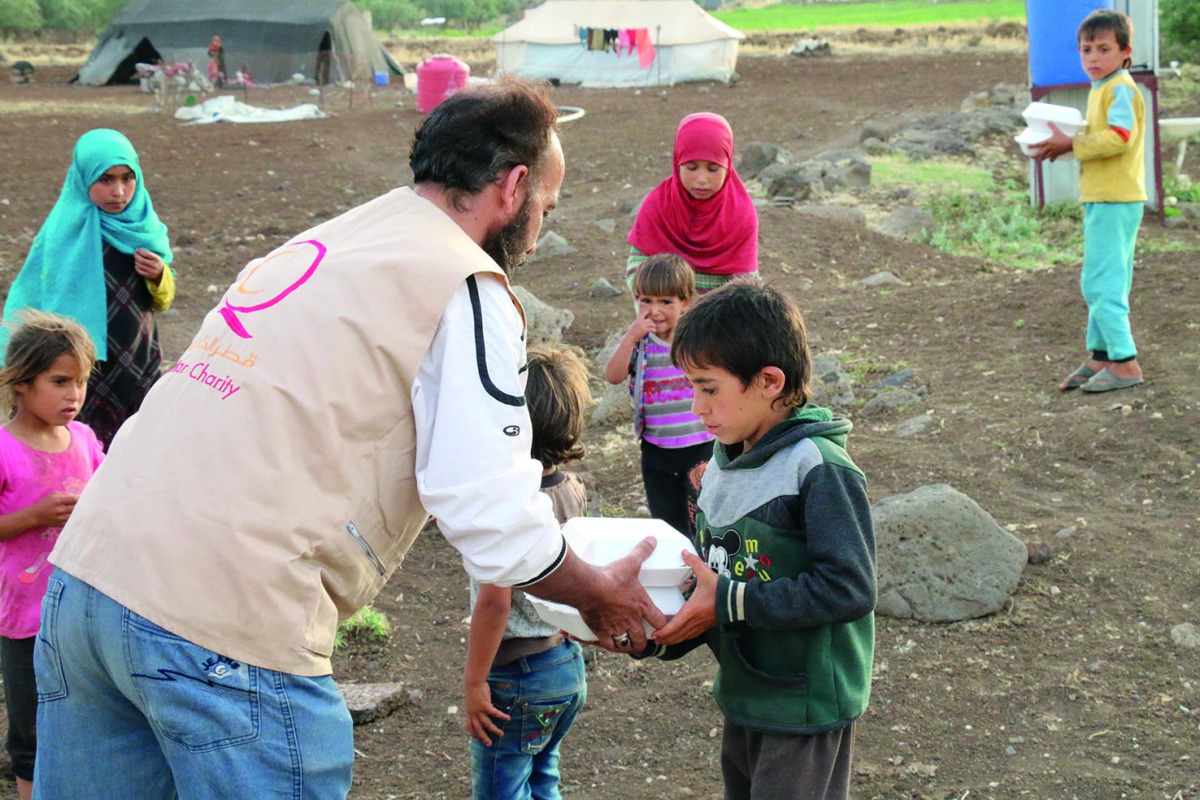 Qatar Charity volunteers distributing iftar meals.