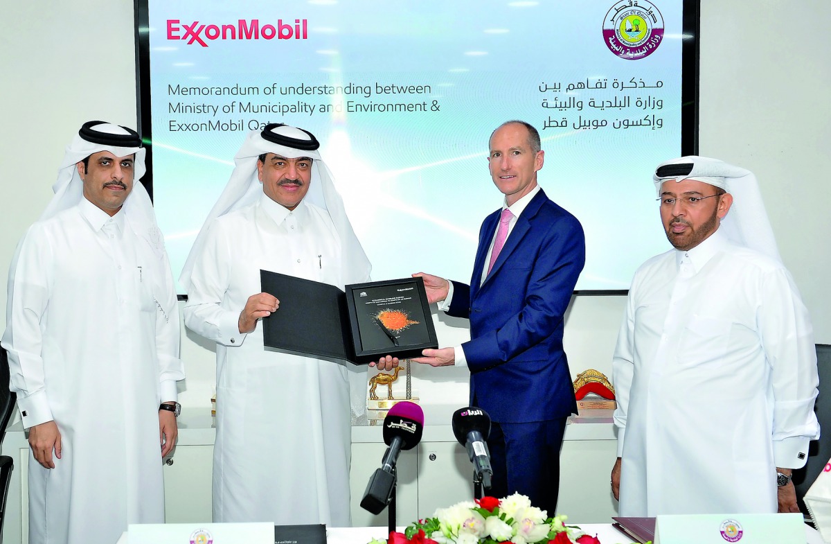 The Minister of Municipality and Environment, H E Mohamed bin Abdullah Al Rumaihi (second left), and  President and General Manager of ExxonMobil Qatar, Alistair Routledge, with the signed MoU, at the Qatar Science and Technology Park in Doha, yesterday. 