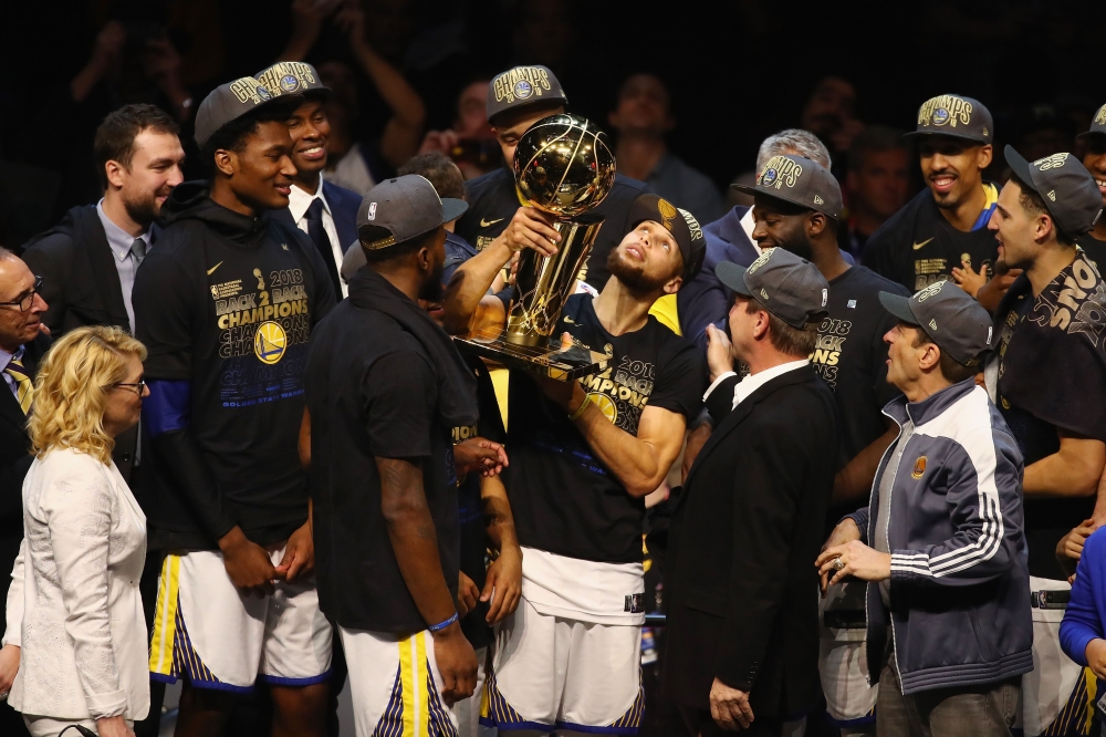 Stephen Curry #30 of the Golden State Warriors celebrates with the Larry O'Brien Trophy after defeating the Cleveland Cavaliers during Game Four of the 2018 NBA Finals at Quicken Loans Arena on June 8, 2018 in Cleveland, Ohio. Justin K. Aller/Getty Images